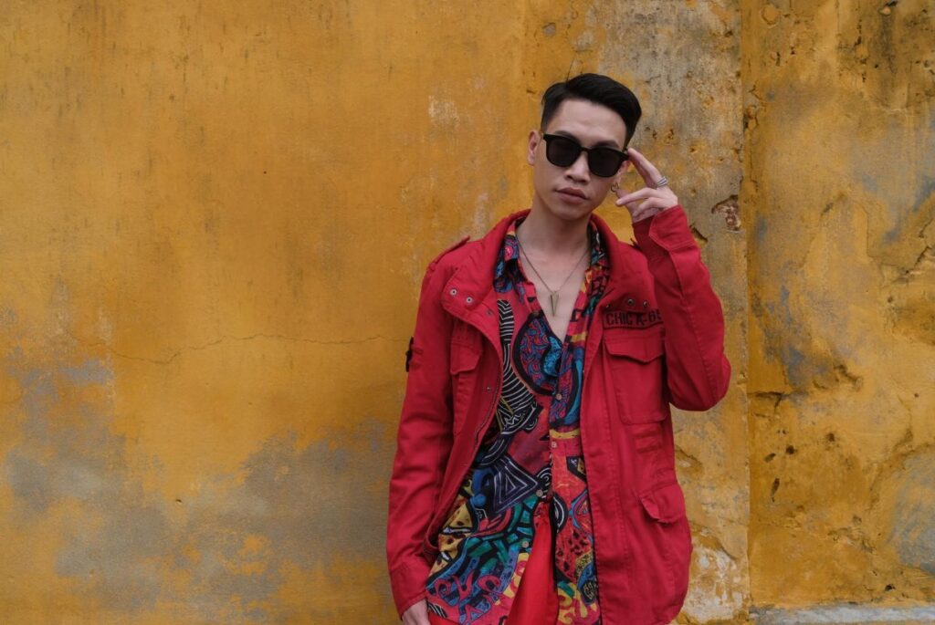 DJ Hee of 92 Hertz posing against Hoi An Old Town's iconic yellow historic walls, gearing up for an electrifying New Year's Eve performance at Shore Club, An Bang Beach.