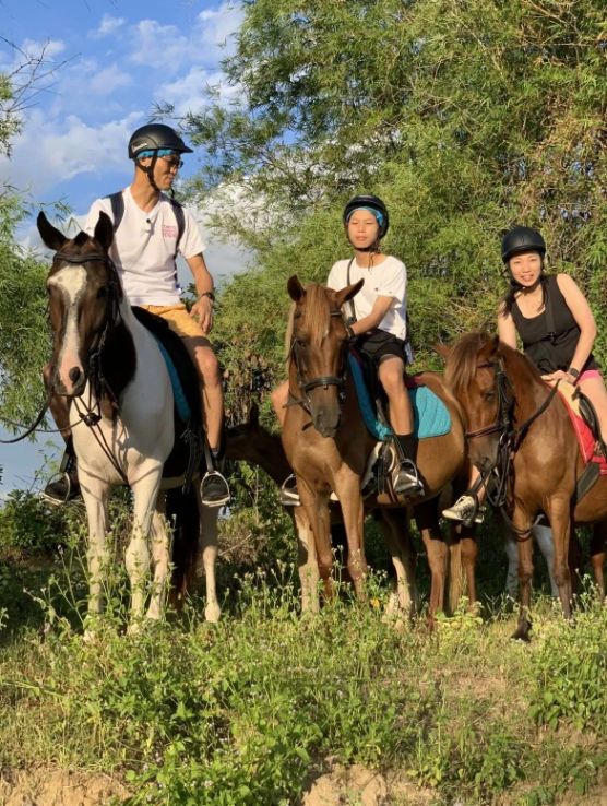 Three guests horseback riding through the scenic countryside near Da Nang, Vietnam