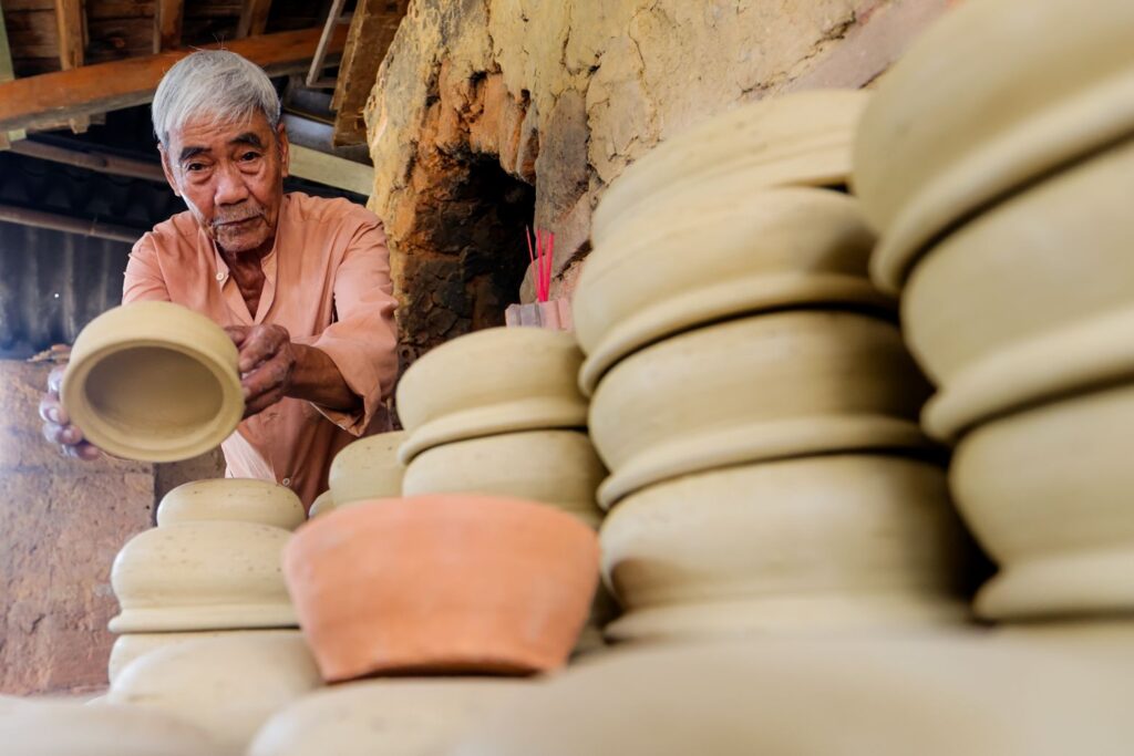 Artisan shaping pottery at Thanh Ha Pottery Village in Hoi An, Vietnam.